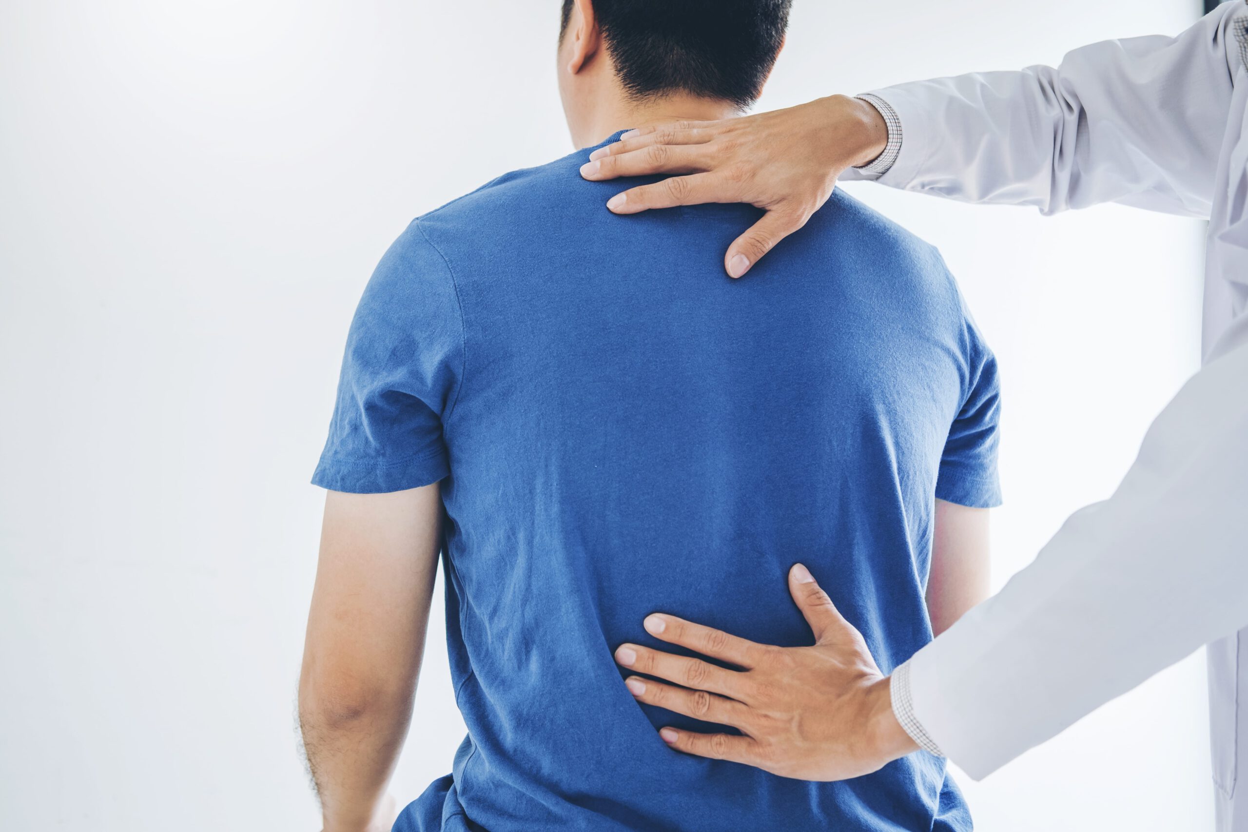 Arzt untersucht die Wirbelsäule eines Patienten